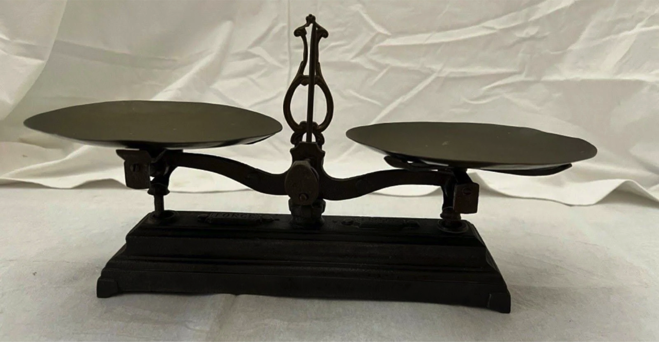 Antique metal balance scale with two pans