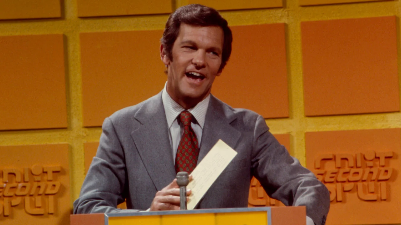 Game show host holding card at podium